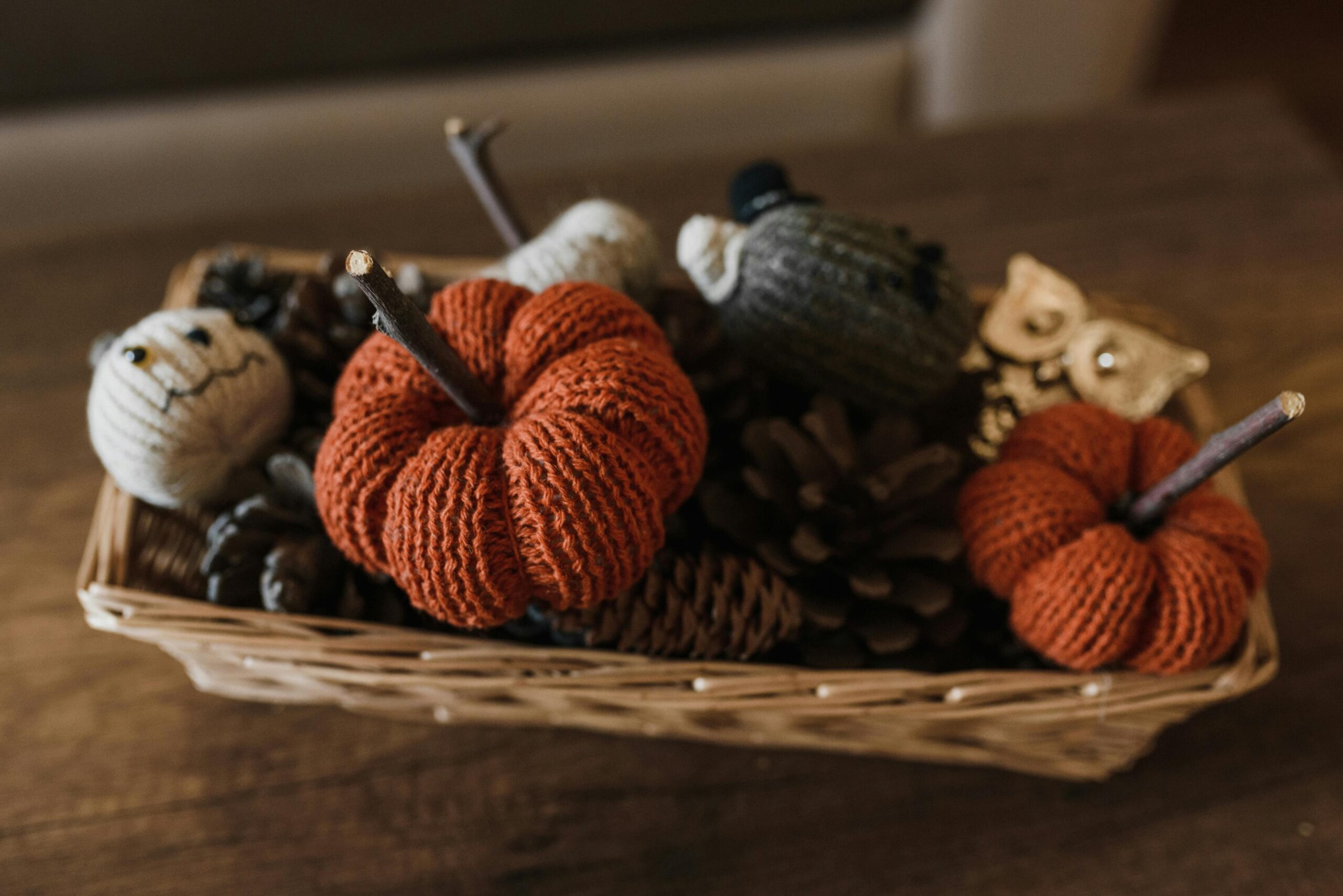 A charming basket of knitted Halloween decorations, perfect for a cozy autumn atmosphere.
