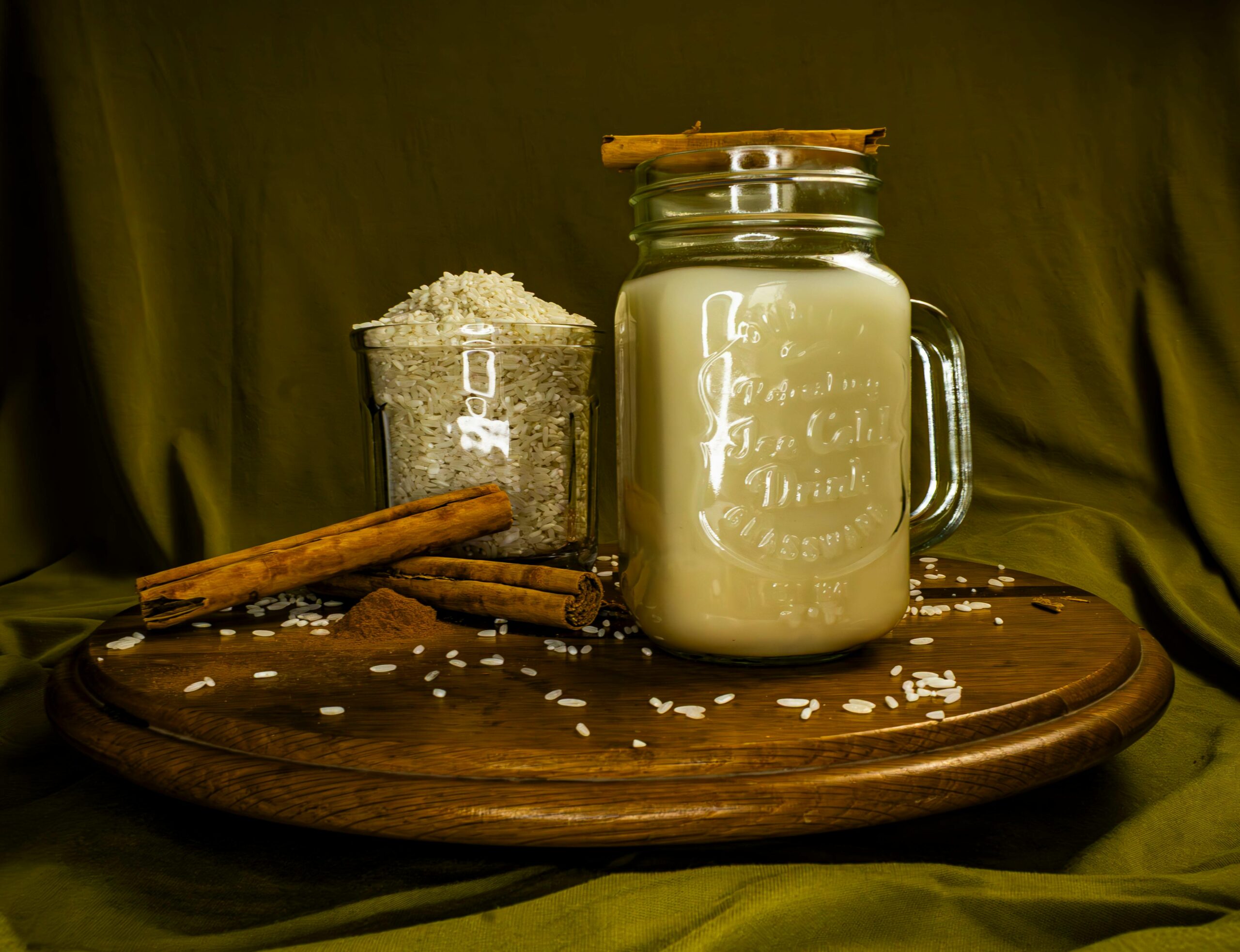 A Mexican horchata drink with rice and cinnamon sticks on a wooden surface, perfect for authentic cuisine.