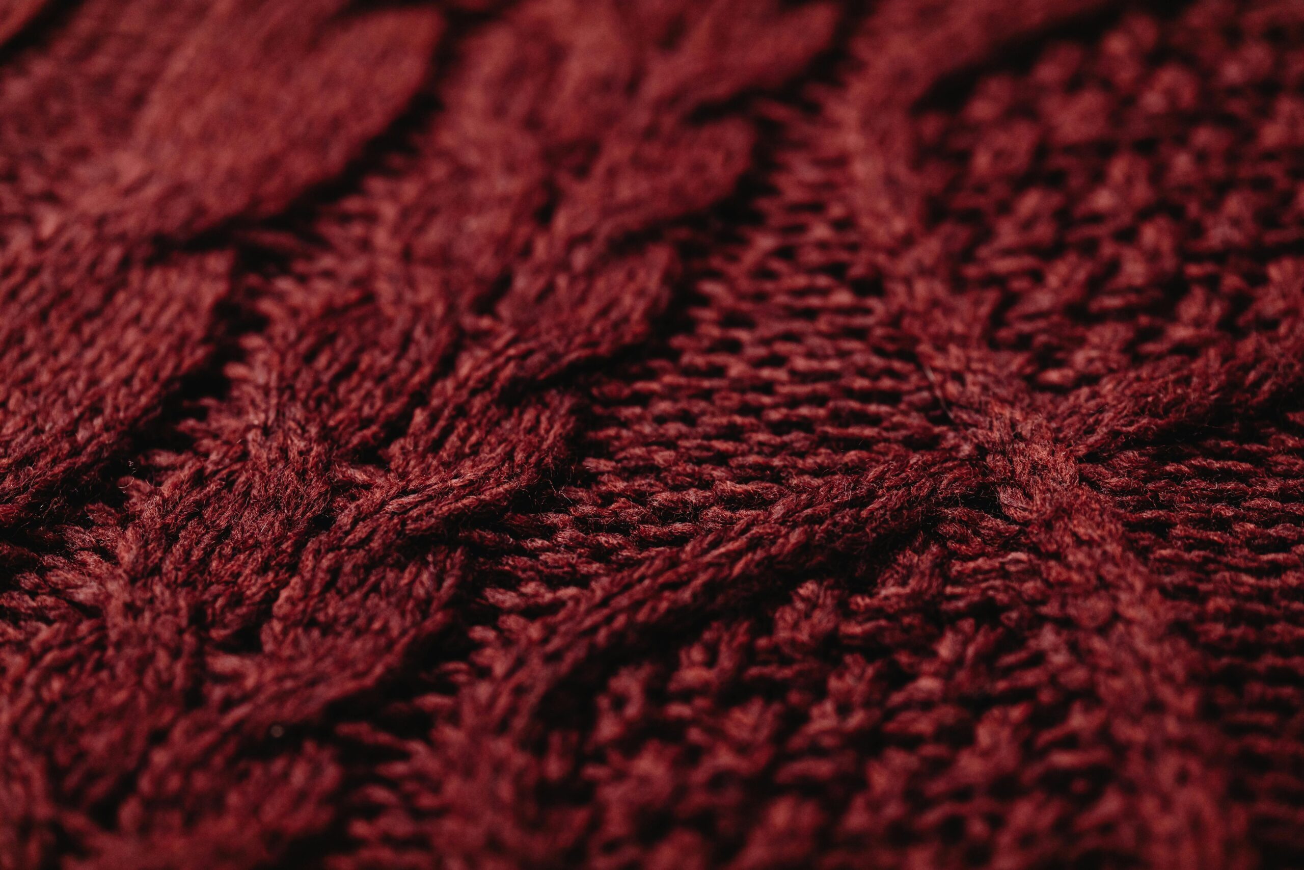 Close-up of hands lighting candles indoors, creating a warm cozy ambiance.