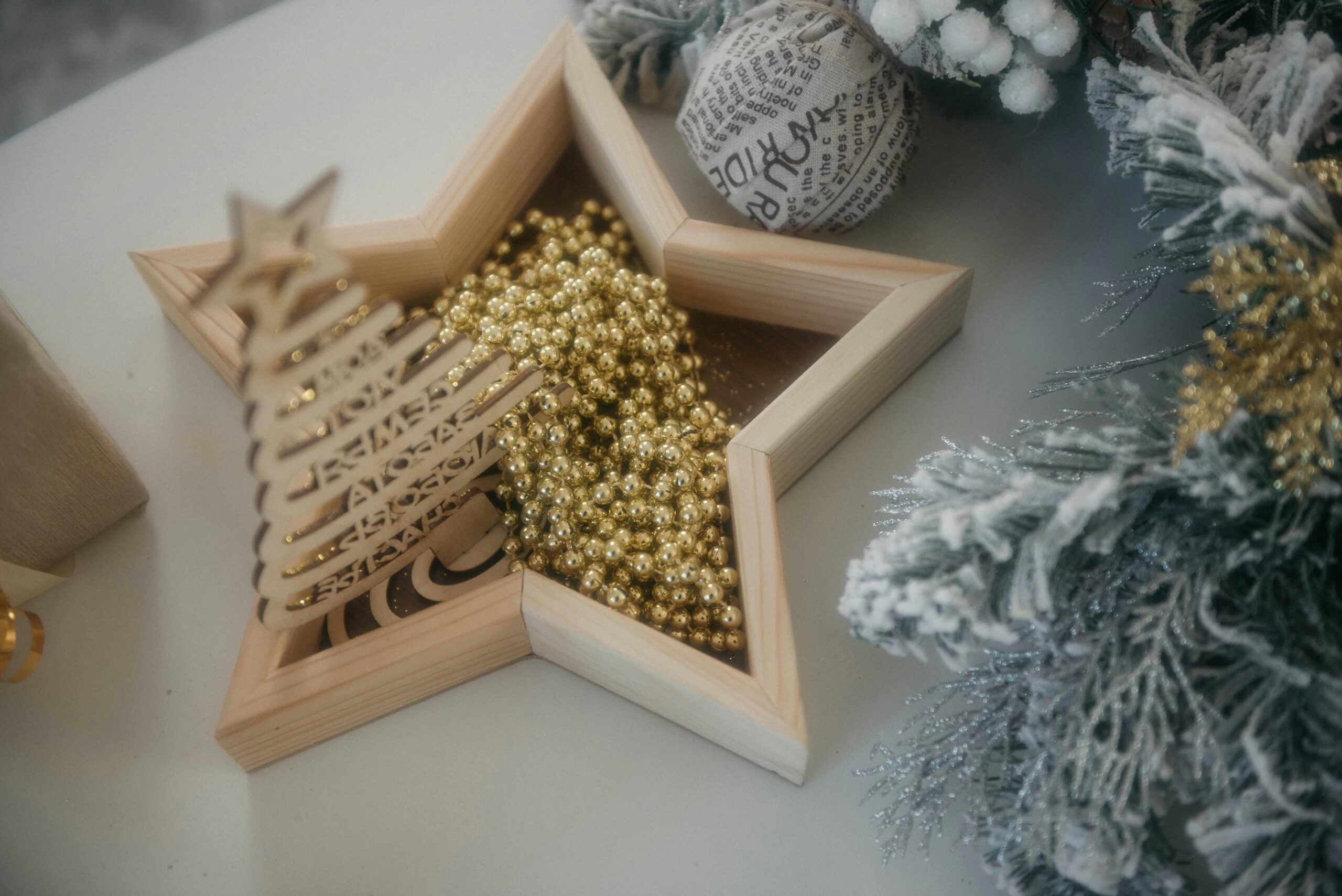 Elegant Christmas decorations featuring golden beads and frosted foliage on a festive table.