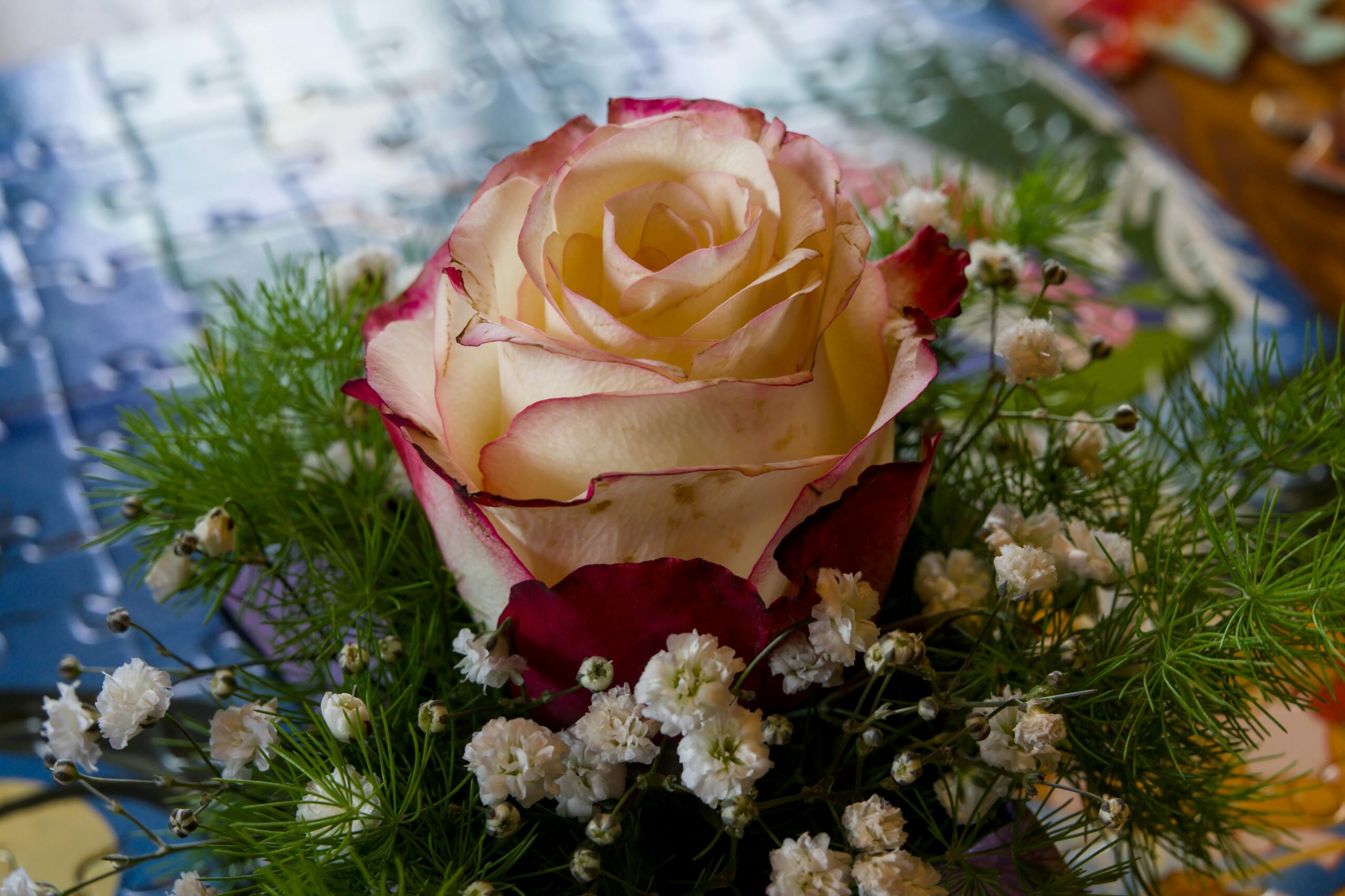 Elegant rose bouquet with delicate white flowers and green foliage.